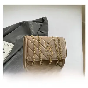 Detail of V-quilted velvet shoulder bag with gold hardware and tassel charm