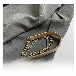 Detail of the golden metal chain and light brown leather拼接 shoulder strap of the bag