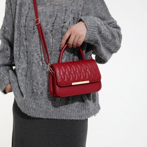 Borsa a tracolla rossa chic trapuntata con cuciture a onda e barra dorata