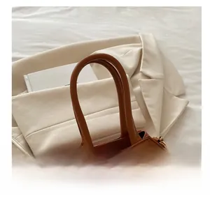 Detailed view of caramel brown fan-shaped handbag with leaf texture on beige blazer