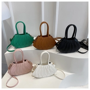 Detailed view of semi-circular shell handbags featuring stylish pleated leaf textures