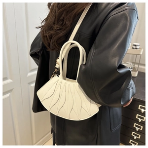 Artistic white fan-shaped handbag with unique petal stitching on black leather jacket