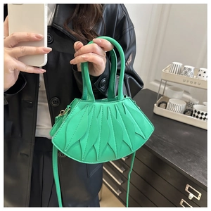 Detail of unique leaf-shaped green shoulder bag with distinctive fan-like pleated texture