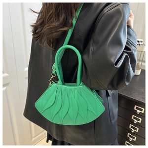 Detail of green fan-shaped handbag with textured leaf pleats and gold metal hardware