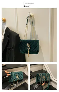 Detail of green velvet shoulder bag featuring V-shaped quilting and gold metal tassel logo