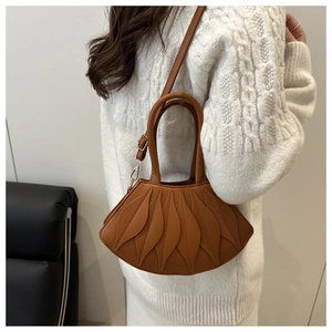 Detail of caramel brown lotus leaf handbag with textured stitching and gold hardware