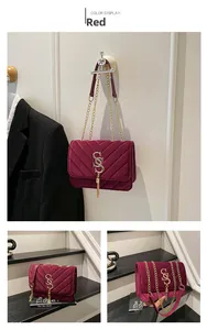 Macro detail of red velvet crossbody bag featuring V-quilted stitching and gold chain tassel