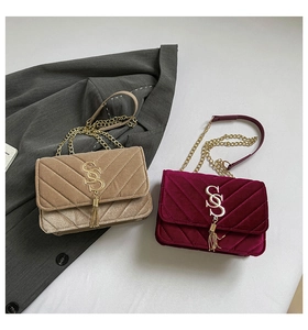 Detail of velvet chain bags with V-shaped quilting and gold SS metal logo with tassels