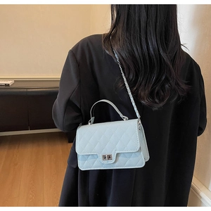 Back view of light blue quilted chain crossbody bag showing size and styling on model