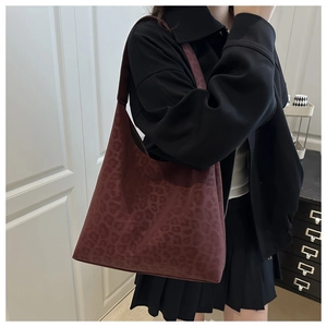 Dettaglio della borsa hobo leopardata rosso scuro indossata con outfit autunnale