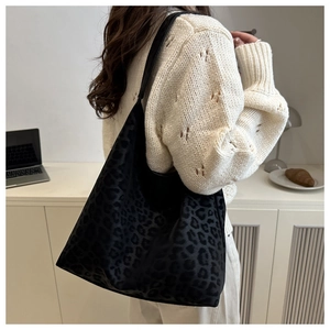 Elegante borsa tote leopardata indossata da una modella in un ufficio minimalista