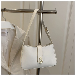 Detailed view of cream-colored shoulder bag featuring a gold gourd-shaped metal buckle