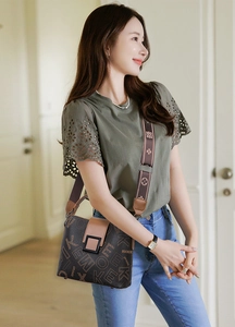 Detail of vintage bucket bag with monogram print and floral embroidered strap