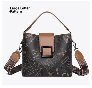 Macro shot of brown leather bucket bag with large letter patterns and black square hardware