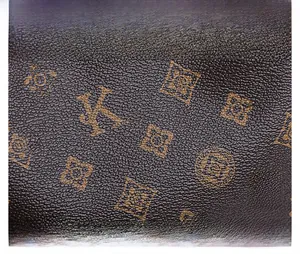 Close-up of premium brown leather texture with golden floral and letter patterns