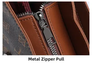 Detail view of the metal zipper pull and premium red fabric lining inside the handbag