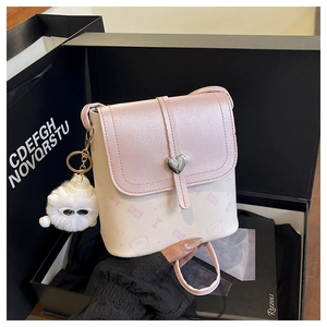 Detail of crossbody bag with heart buckle, glitter flap, and pink cartoon patterns