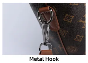 Close-up of durable silver hardware hook and monogram leather strap on a shoulder bag