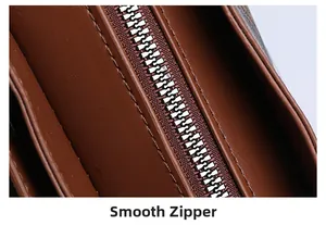 Macro shot of the smooth metal zipper and premium leather texture on the brown bucket bag