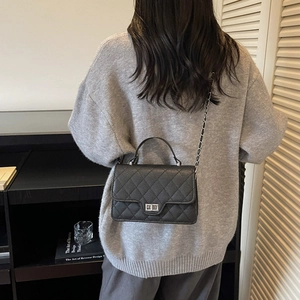 Classic black quilted crossbody bag with silver chain strap and metal lock closure