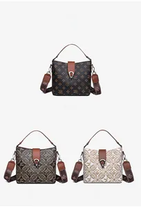 Close-up of three vintage monogram bucket bags with wide straps and metallic locks
