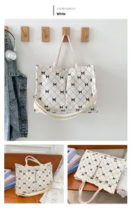 Detail view of large corduroy tote bag with black bow print and front pockets