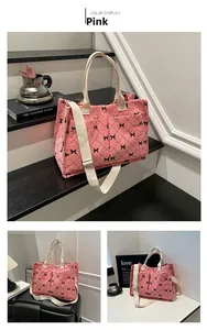 Detailed view of pink corduroy tote bag with black bow print and adjustable straps