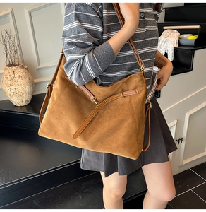 Détail d'un sac hobo en daim marron avec boucle en métal et bandoulière ajustable