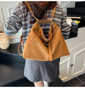 Détail du sac à bandoulière en daim marron avec sangle réglable et boucle métal