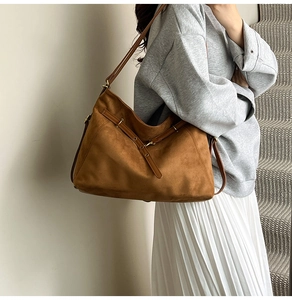 Vue latérale d'un grand sac cabas en daim marron porté par un mannequin en style urbain