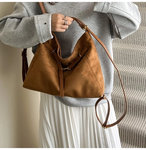 Détail du sac hobo en daim marron avec boucles en métal doré et bandoulière réglable