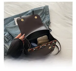 Detail show of ethnic crossbody bag interior holding a smartphone and wallet