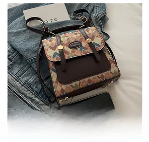 Size comparison of a vintage geometric woven crossbody bag with leather trim next to a phone