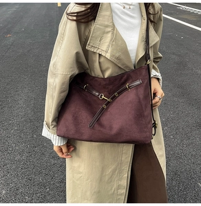 Détail du sac hobo en daim bordeaux avec lanières en cuir et boucles dorées vintage