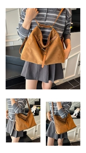 Détail montrant la texture du cabas en daim marron et l'attache en métal bronze