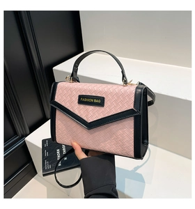 Detail of pink and black woven texture handbag with fashion bag logo and envelope flap