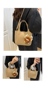 Detail of beige lychee grain bucket bag with adjustable strap and plush monster charm