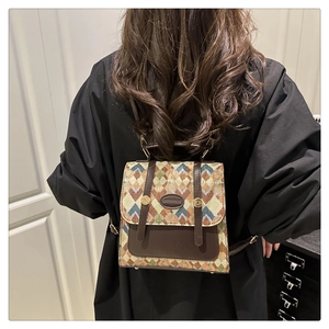 Back view of a mini vintage jacquard backpack with brown leather trim on a model