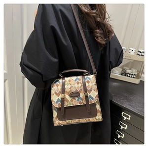 Detail of vintage jacquard crossbody bag with geometric patterns and leather trim