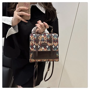 Detail of vintage jacquard mini backpack showing geometric texture and leather strap