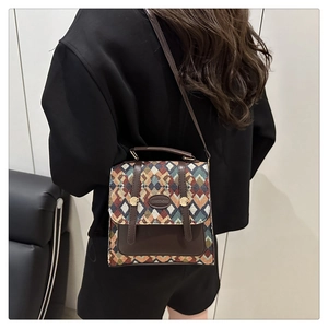 Detail of vintage geometric pattern woven fabric and brown leather strap on luxury crossbody bag