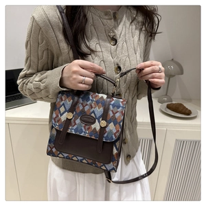 Detail of vintage geometric jacquard handbag with leather trim and metal clasp closure