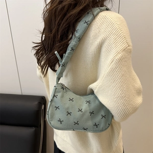 Mint green corduroy underarm bag with black bow print and comfortable wide strap