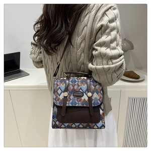 Close-up of geometric textured fabric crossbody bag with leather trim and metal logo