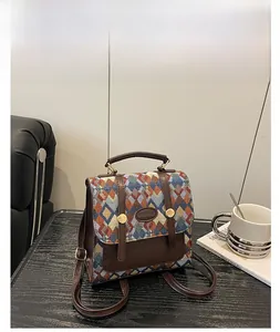 Close-up of a blue quilted multi-way backpack on a leather chair with coffee accessories