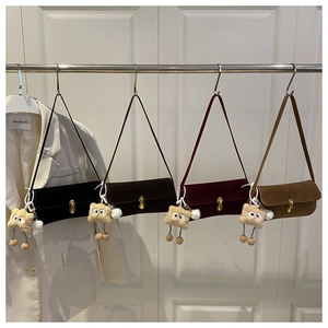Vue détaillée de quatre sacs en velours avec fermoirs dorés et breloques peluches