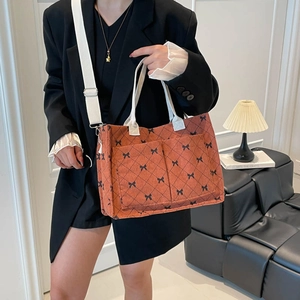 Retro orange corduroy tote bag with black bow patterns and adjustable shoulder strap