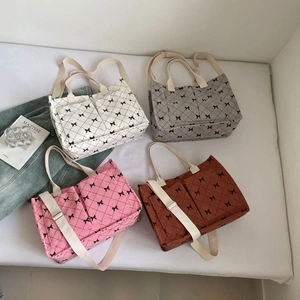 Quilted corduroy tote bags in multiple colors with delicate black bows and dual straps