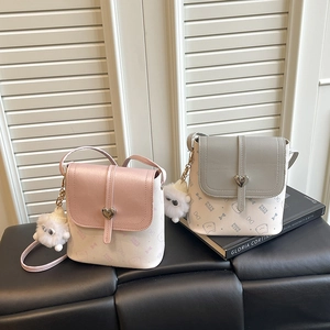 Crossbody bag with cat print and heart clasp, featuring a cute plush kitten keychain