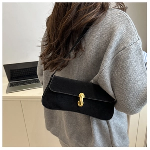 Gros plan sur le sac sous le bras en daim noir avec boucle en métal doré